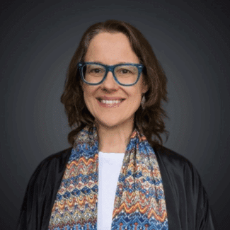 Abby Robinson smiling at the camera against a gray background.